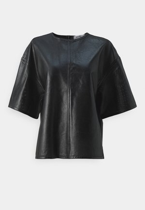Sort læder top med korte ærmer, tekstureret mønster, rund halsudskæring og lynlås i ryggen. Løs pasform med en ren, moderne silhuet.