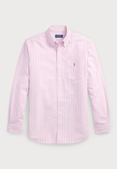 Heledane roosa nööpidega särk, millel on vertikaalsed sinised ja valged triibud. Omab teravat kraed ja väikest logo rindkere taskul.