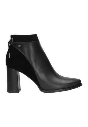 Stivaletto nero con tacco basso realizzato in pelle liscia e suede, dotato di punta affusolata e un piccolo dettaglio con logo vicino alla caviglia.