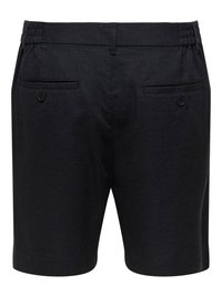 Short noir sur mesure avec taille élastique et deux poches passepoilées boutonnées à l'arrière.