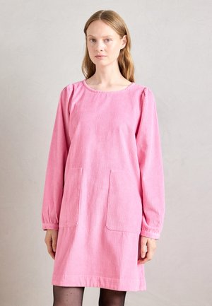Rosa Corduroy-Kleid mit langen Ärmeln, rundem Ausschnitt und zwei vorderen Taschen. Vertikale Rippstruktur und Saum endet über dem Knie.