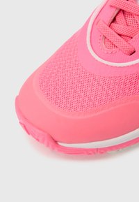 Rosa treningssko med et mesh-overside, avrundet tå og gummisåle. Har snøring, teksturert overflate og hvite detaljer langs mellomsålen.