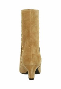 Bottines en daim beige avec un petit talon, décorées de petits clous ronds sur les côtés.