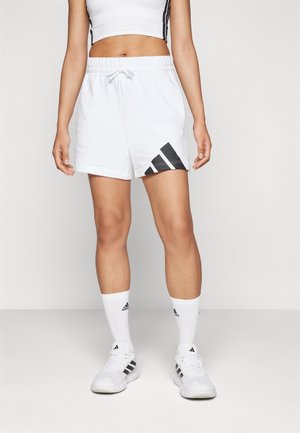 Shorts de sport blancs avec une taille élastique, présentant des rayures noires diagonales et un logo Adidas sur le bas à gauche.