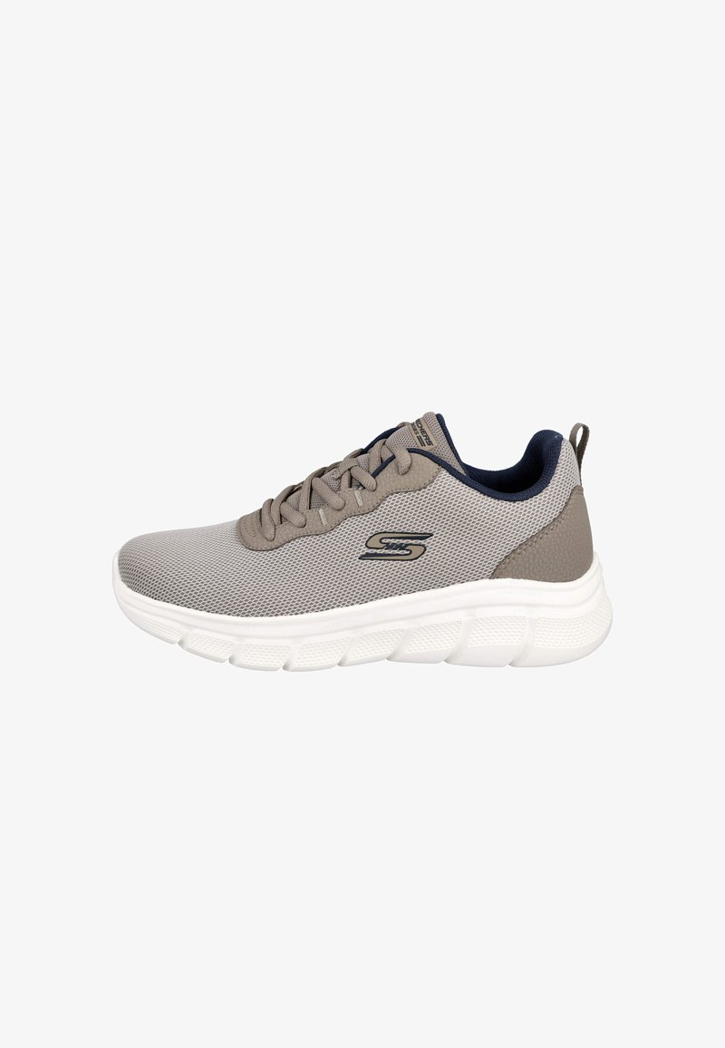 Zapatilla de malla gris con suela blanca acolchada, acentos en azul marino y cordones planos. Presenta un logo en el lateral y una lengüeta en el talón.