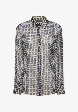 Blouse légère et semi-transparente à manches longues avec col, ornée d'un motif bleu répétitif sur fond crème. Comprend des fermetures à bouton.
