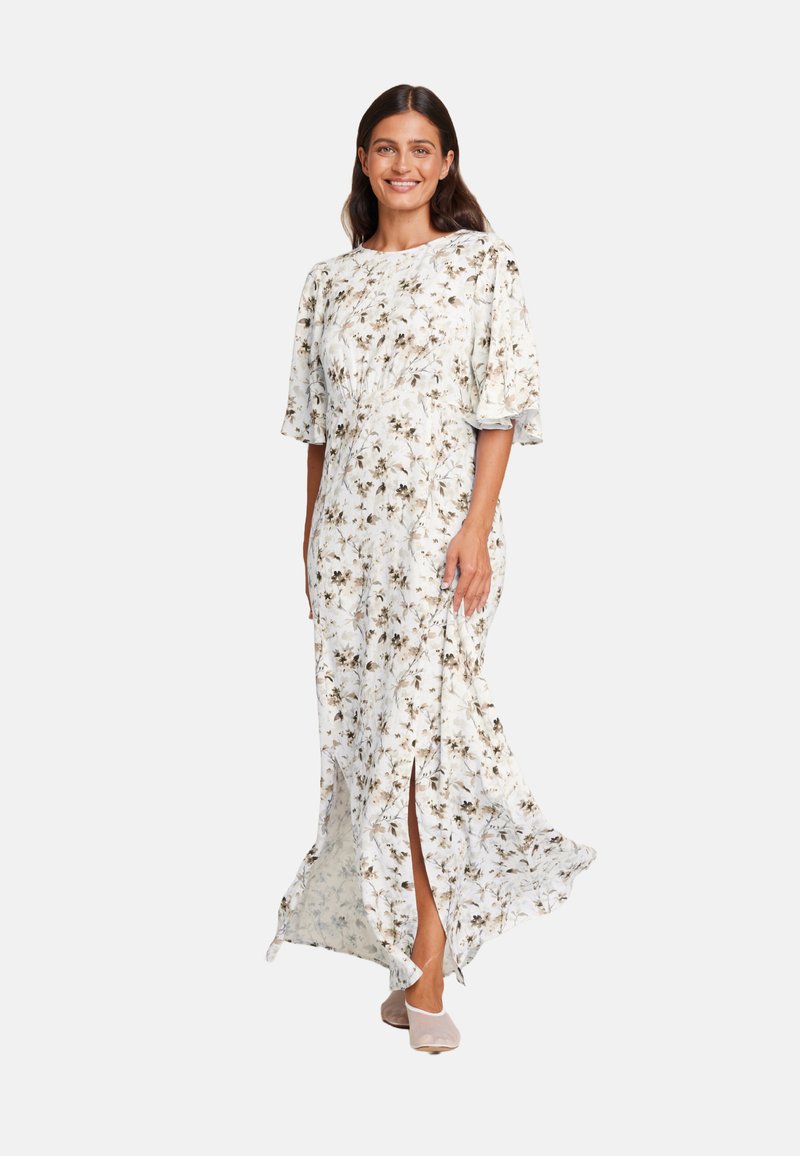 Blomstret maxi-kjole i lett stoff med korte flommelser, med hvit bakgrunn og brune blomster mønstre, sidespalter og en avslappet passform.