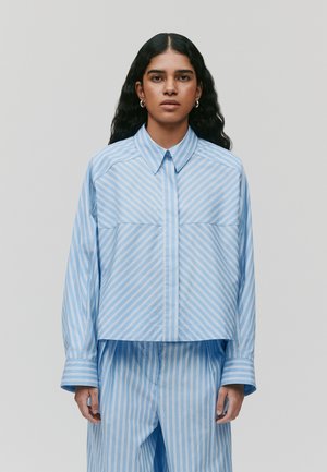 Blauw-witte gestreepte cropped shirt met lange mouwen, knoopjes aan de voorkant en twee borstzakken, gemaakt van gladde stof. Gepaard met bijpassende broek.