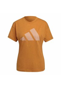 Oranžové bavlněné tričko s krátkými rukávy a kulatým výstřihem, na přední straně s velkým světle růžovým logem Adidas. Tričko má strukturovaný povrch.