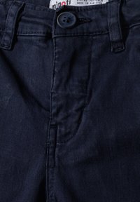 Pantalons en coton bleu marine avec une texture lisse, dotés d'une fermeture à bouton, de poches avant et de détails cousus le long des coutures.