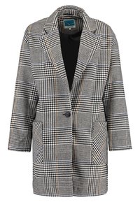 Kavaj i svartvitt hundtandsmönster med bruna detaljer, med en knapp, två fickor och en notcherad krage.