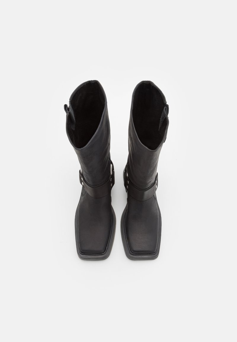 Schwarze Lederstiefel in Knielänge mit quadratem Fuß, verfügen über eine glatte Textur und einen Schnallenverschluss am Knöchel. Das Innenfutter aus Wildleder ist sichtbar.