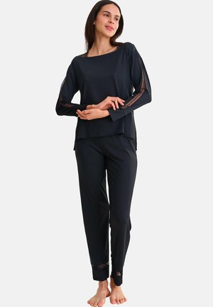 Cet ensemble de vêtements d'intérieur noir comprend un haut à manches longues avec des accents en dentelle et un pantalon ample avec des garnitures en dentelle aux poignets. Tissu doux, design décontracté.