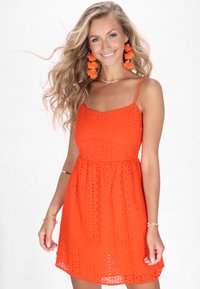 Rochie portocalie strălucitoare cu un model texturat tip eyelet, corset fotomodelat și fustă evazată. Prezintă bretele subțiri și un decolteu cu margine crestată.