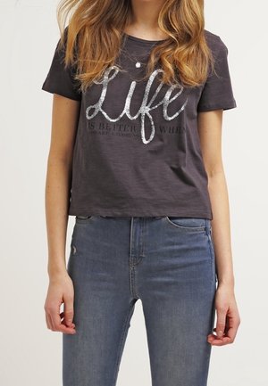 T-shirt grigio scuro a maniche corte con una scritta metallizzata argento "La vita è migliore quando ridi" sul davanti, abbinato a jeans blu.