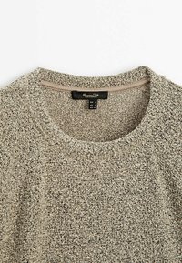 Pull en maille beige texturée avec un col rond et une étiquette de marque « Massimo Dutti » cousue à l'intérieur du col.
