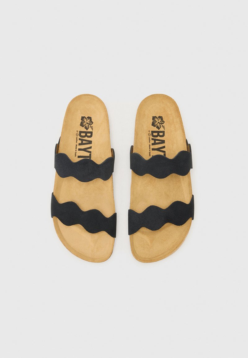 Czarne zamszowe klapki z falistymi paskami, z tanowym wyściełanym wkładką oraz kwiatowym logo na wewnętrznej stronie. Płaski, otwarty przód.