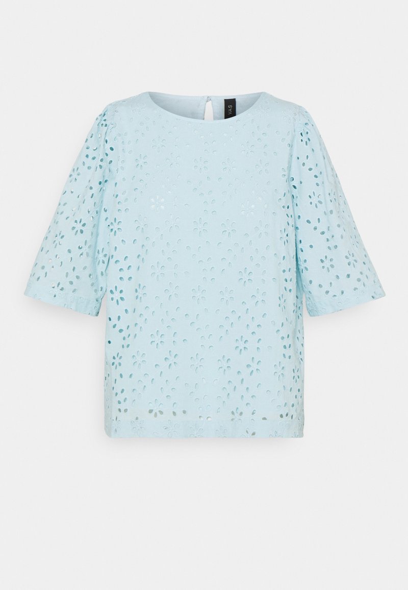 Blouse bleu clair à manches courtes avec motif floral en broderie anglaise et encolure ronde, présentée sur fond blanc.