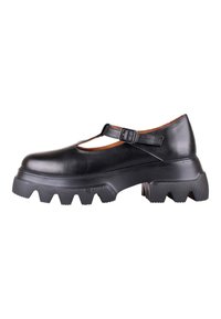 Chaussure Mary Jane en cuir noir avec semelle épaisse à rainures et bride réglable à boucle, vue de côté sur fond blanc.