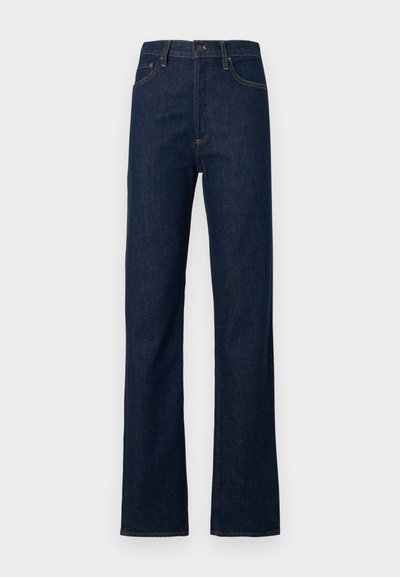 Tmavomodré rifľové nohavice so strihom rovné nohavice, vysokým pásom, piatimi vreckami a kontrastným oranžovým prešitím. Jemná textúra bez výrazných vzorov.