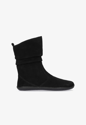 Botte noire en suède doux mi-mollet avec semelle en caoutchouc plate, bout arrondi et design supérieur décontracté.