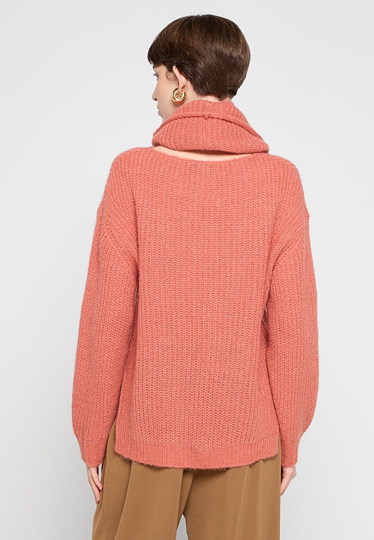 Maglione oversize in maglia testurizzata di un morbido corallo, con collo a cascata, spalle cadenti e una vestibilità rilassata. Caratterizzato da orli a costine.