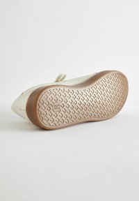 Scarpa in pelle bianca con tomaia testurizzata, caratterizzata da una punta rotonda e una suola in gomma flessibile con battistrada decorato per una migliore aderenza.