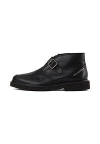 Black leather ankle boot with a rounded toe, side buckle detail, and textured sole; features a minimalist design and smooth finish.
