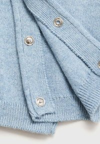 Svetlomodrý pletený kardigán so striebornými cvokmi, rebrovanými manžetami a mäkkou, textúrovanou látkou s čistým dizajnom.