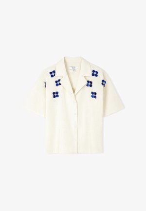 Korte mouwen, button-up overhemd van off-white linnen met blauwe bloemige borduursels op de schouders. Voorzien van een klassieke kraag en een relaxte pasvorm.