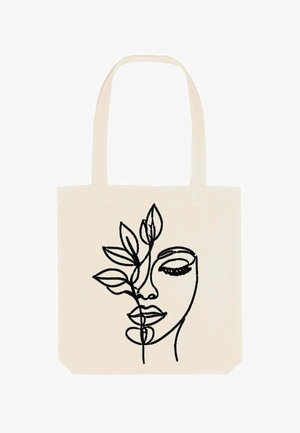 Borsa in cotone color crema con disegno a linee nere di un volto parzialmente nascosto da foglie, dotata di due manici robusti e una superficie liscia.