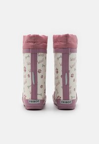Bottes imperméables roses avec un design à motifs comprenant des empreintes de pattes et des os, en matériau en caoutchouc, et un haut souple et pliable.