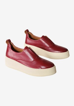 Piros bőr slip-on cipők lekerekített orral és vastag krémszínű platform talppal. Hátul kis húzófüllel díszítve.
