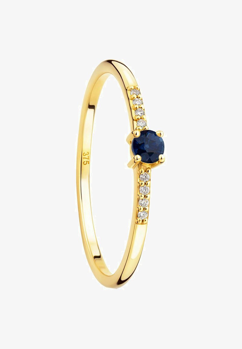 Zlati prstan z okroglim modrim safirjem na sredini, obdan s petimi majhnimi prozornimi kamni ob eni strani traku.