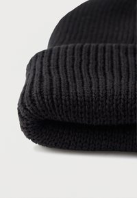 Fekete kötött sapka bordázott mintával és behajtott kialakítással, puha, vastag fonalból, amely a melegséget és a kényelmet hangsúlyozza.