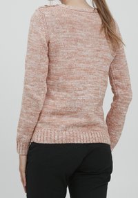 Maglione lavorato a maglia in mélange rosa e crema, presenta maniche lunghe, orlo a coste e dettagli con bottoni sulla spalla, realizzato in morbido materiale tessile.