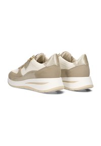 Beige und cremefarbene Sneaker mit einer strukturierten Oberseite, metallischen Akzenten und einer dicken weißen Sohle. Ein Reißverschlus Detail an der Seite sorgt für Funktionalität.