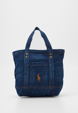 Sac fourre-tout en denim bleu foncé avec double poignée et petite poche avant ornée d'un emblème de joueur de polo orange cousu.