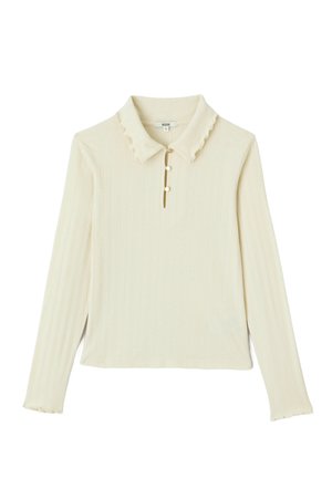 Haut à manches longues côtelé crème avec col festonné, patte de boutonnage à trois boutons et manches légèrement évasées. Texture douce, design décontracté.