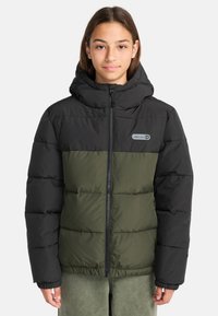 Giacca a vento con una parte superiore nera e una parte inferiore verde oliva, dotata di chiusura a zip, cappuccio e un patch con logo sul petto.