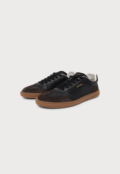 Paire de baskets en cuir noir et marron foncé et en daim avec semelles en caoutchouc marron et logo Versace sur le côté et la languette.