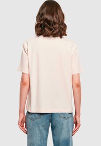 Kortærmet, lys pink t-shirt med en afslappet pasform, lavet af blødt stof. Bagsiden har et enkelt, rent design uden synlige logoer.