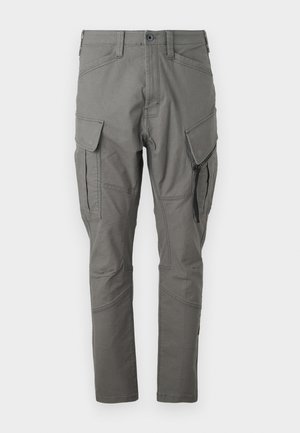 Grå cargo bukser med en tapered fit, laget av slitesterkt stoff. Har flere lommer, inkludert sidelommer og glidelåslommer, med sømdetaljer.