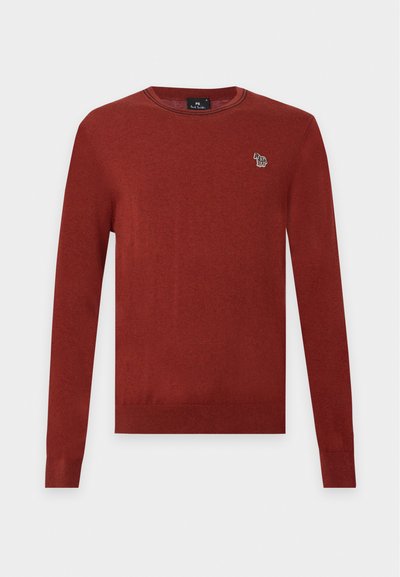 Pull manches longues couleur rouille à col rond avec petit logo zèbre multicolore sur le côté gauche de la poitrine.