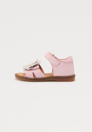 Sandale en cuir rose avec accent de fleur, design ouvert à l'avant, bande réglable et semelle en caoutchouc marron. Style plat et décontracté pour les enfants.