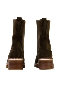 Botas de tobillo de ante marrón con un panel de tela acanalada, tacón apilado y costuras decorativas blancas a lo largo de la suela. Vista trasera de las botas.