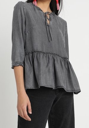 Top peplum grigio in denim leggero, con scollatura rotonda e un fiocco, maniche a tre quarti e dettagli elastici.
