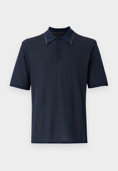 Mørkeblå kortermet polo-skjorte med ribbet tekstur, tre-knappings placket og kontrasterende kragekant. Glatt stoff, klassisk design.