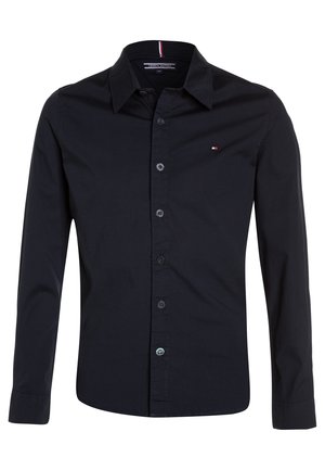 Czarna męska koszula z długim rękawem zapinana na guziki, z kołnierzykiem, z małym logo Tommy Hilfiger na piersi oraz z nadrukowanym paskiem wewnętrznym kołnierzyka.