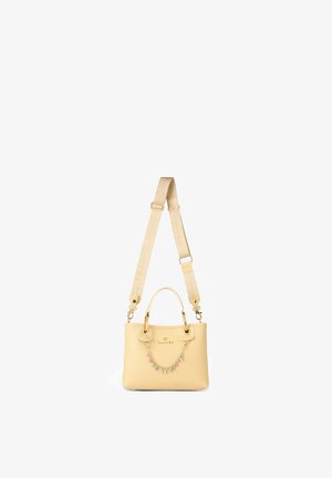 Beige handbag with adjustable shoulder strap, small handles, gold-tone hardware, and a colorful charm chain spelling "BROCOLINI".